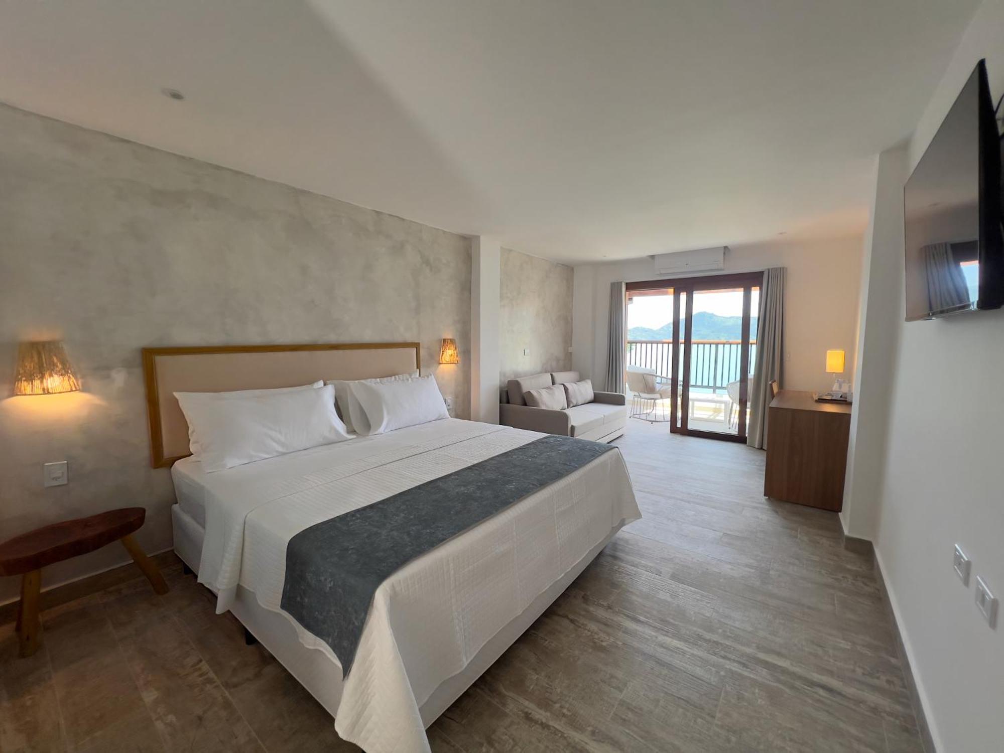 Quarto com cama king-size, varanda e vista do mar
